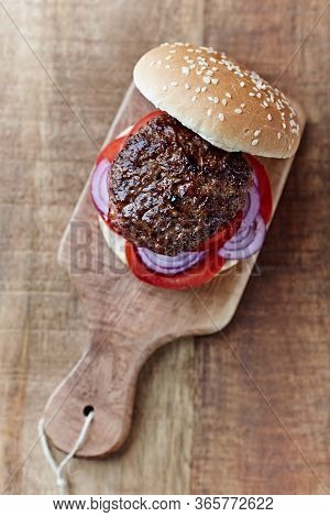 Tasty Humburger With Tomatoes And Red Onion. Rustic Stone Background. Top View.