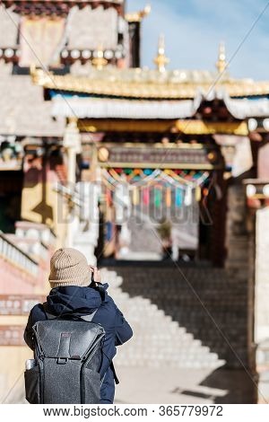 Young Man Traveler With Sweater And Backpack Traveling In Songzanlin Temple, Happy Photographer Taki