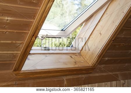 Open Dormer Window In Wooden House In The Attic. Room Has Sloping Ceiling Made Of Natural Eco-materi