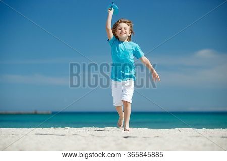 Child Boy Plays At Sea With An Airplane. Dream To Travel.