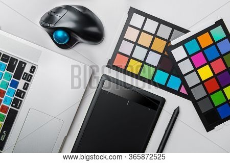 Top View Of Graphic Designer Desk. Laptop, Trackball Mouse, Digital Graphic Tablet