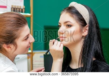 Makeup Artist Makes Outline With Lip Pencil On Lips Of Model In Beauty Salon.