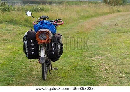 A Bicycle Laden With Bags Stands On The Road Among