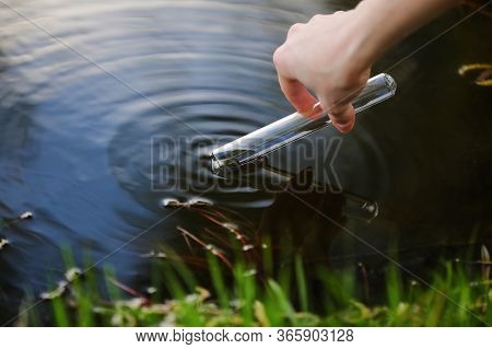 Scientist And Biologist Hydro-biologist Takes Water Samples For Analysis Outdoors. Hand Is Collects 