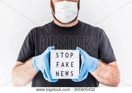 Fake News Infodemics During Covid-19 Pandemic Concept. Man Wearing Protective Mask And Medical Glove
