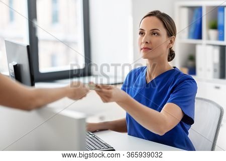 medicine, people and healthcare concept - female doctor or nurse and patient with insurance or credit card card at hospital