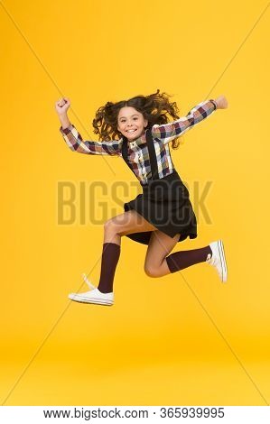 Energy And Ambition. Energetic Girl Run To School. Happy Child In Midair Yellow Background. Childhoo