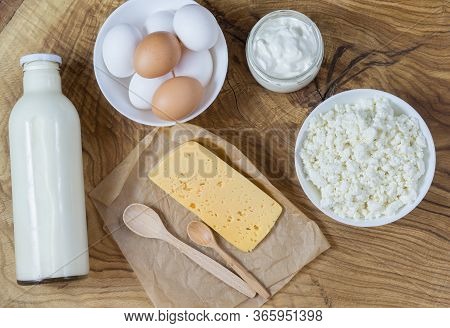 Rustic Products On A Textured Wooden Table: Milk, Cottage Cheese, Eggs, Sour Cream And Cheese. Healt