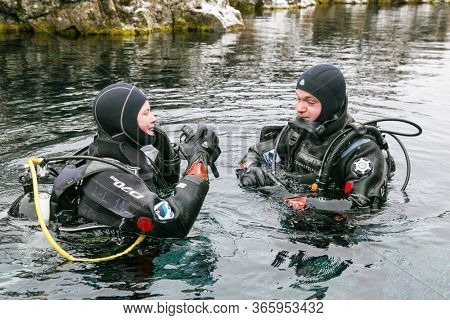 Silfra, Iceland-Feb 19, 2020: Scuba divers preparing entering in the water at Silfra rift, the place where Eurasian and the American tectonic plate are divided in Thingvellir National Park, Iceland. 