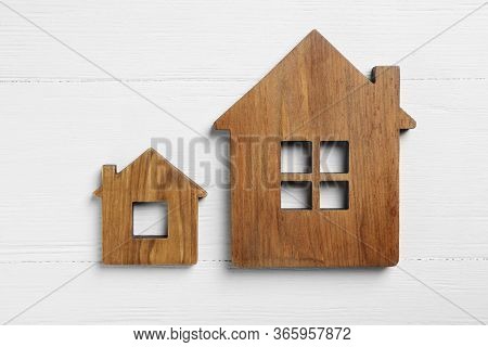 Small And Big House Figures On White Wooden Background, Flat Lay. Pareto Principle Concept
