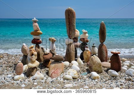 Concept of balance and harmony. Stones pebbles stacks on the beach coast of the blue sea in the nature. Meditative art of stone stacking.