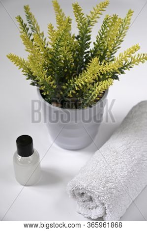 The Bottle Of Natural Herbal Shower Gel For Women With Towel On The Table With Flowers In Bathroom