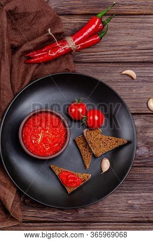Ajvar Or Pindjur Red Vegetable Spread Or Pepper Paprika And Tomato Mousse In A Clay Bowl In A Black 