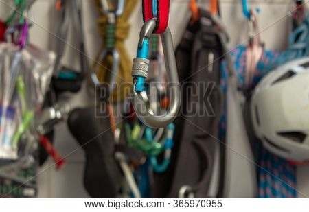 Screwgate Carabiner Attached To A Nylon Sling With A Bunch Of Climbing Gears On The Background