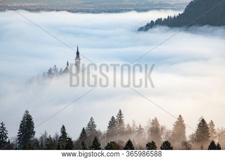 amazing panorama of Lake Bled Blejsko Jezero on a foggy morning with the Pilgrimage Church of the Assumption of Maria on a small island and Bled Castle and Julian Alps in backgroud