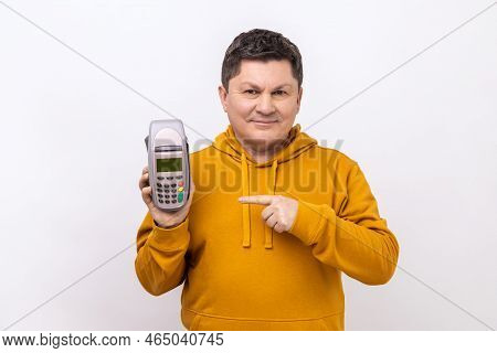 Smiling Positive Man Holding And Pointing At Pos Payment Terminal, Using Paypass For Purchases Payme