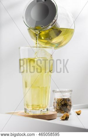 Pouring Chrysanthemum Iced Tea Into Glass On The White Table