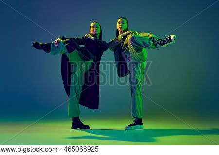 Young Stylish Flexible Girls In Modern Attires Dancing Contemp Style Dance Isolated Over Gradient Bl