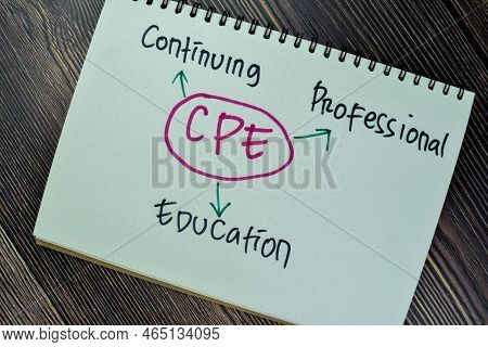 Concept Of Cpe - Continuing Professional Education Write On Sticky Notes Isolated On Wooden Table.