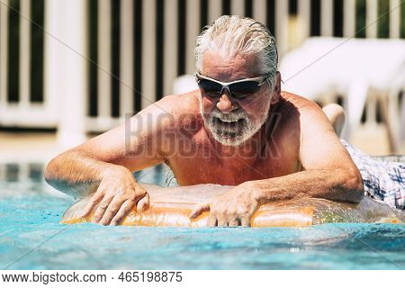 Happy Cheerful Caucasian People Old Senior Man Lay Down On Coloured Trendy Lilo Enjoying The Swimmin