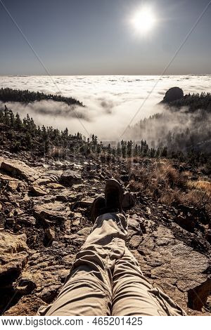 Man Legs Point Of View With Trekking Active People Resting On The Rocks And Enjoying The Beautiful W