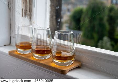 Flight Of Single Malt Scotch Whisky Served On Old Window Sill In Scottisch House With View On Old Pa
