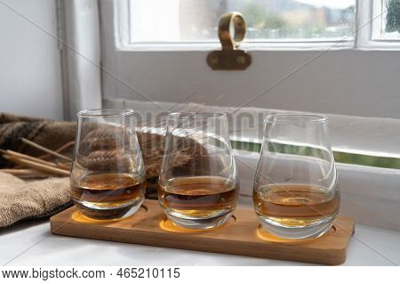 Flight Of Single Malt Scotch Whisky Served On Old Wooden Window Sill In Scottisch House In Edinburgh