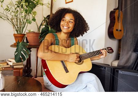 Smiling Afro Americal Young Woman Playing Acoustic Guitar. Girl Playing The Guitar