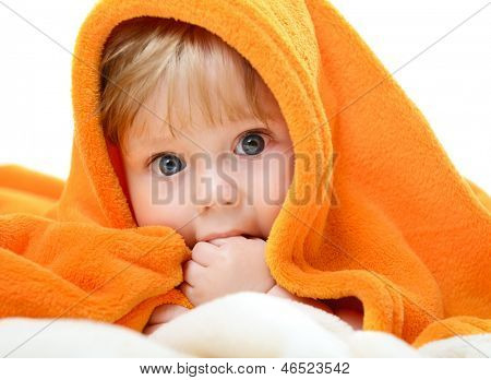 ภาพของเด็กทารกน่ารักนอน plaid สีส้ม และดูดนิ้วมือของเขา