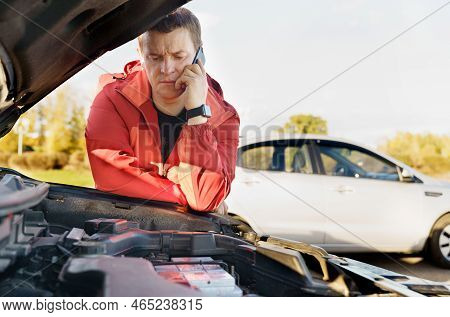 A Male Driver Stands Near The Engine Compartment Of The Car, Calls The Phone - Asks For Help. Transp