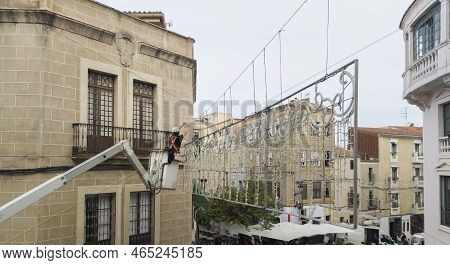 Unidentified Worker At Height Installing Christmas Led Light Decoration. He Is Rised By Telescopic B