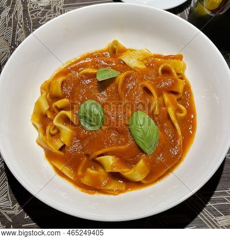 Fresh Made Wide Cut Pasta With Tomato Sauce Served Inside White Bowl.