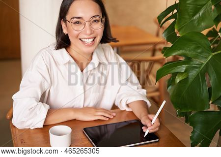 Smiling Young Female Creator, Creative Girl Drawing On Digital Tablet With Graphic Pen, Drinking Cof