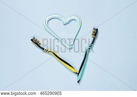 Two Tooth Brushes And A Heart Shaped Brush On A Light Blue Background With Copy Space In The Top Rig