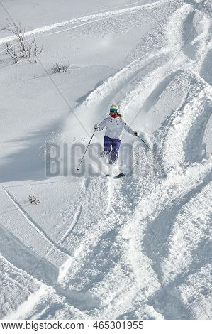 Valmorel, France -circa 2019: Skier Coming Down Fast In Fresh Powder Snow Off-piste Free Ride. Plowi