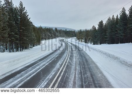 Driving On Snowy Winter Roads Of Finnish Lapland, Arctic Landsape, Icy Asphalt