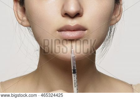 A Womans Face, With An Injection In Her Nose And The Needle Inserted Into Her Lip To Show How She Ha