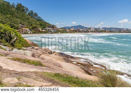 Beach Viewwith Rocks, Forest, Houses And Mountain