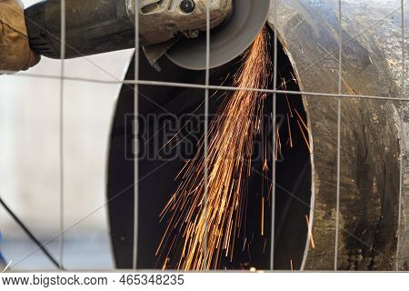 Shallow Depth Of Field (selective Focus) Details With A Worker Using An Angle Grinder On An Industri