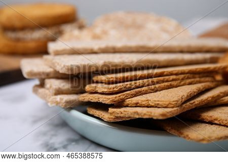 Rye Crispbreads, Rice Cakes And Rusks On White Marble Table, Closeup
