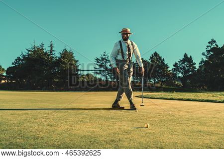 A Fancy African Senior In A Fashionable Outfit With A Straw Hat, Trousers With Suspenders, And A Cig