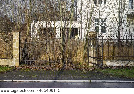 An Abandoned Mansion Broken Entrance Gates And Spearhead Metal Fence