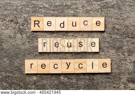 Reduce, Reuse And Recycle Word Written On Wood Block. Reduce, Reuse And Recycle Text On Cement Table