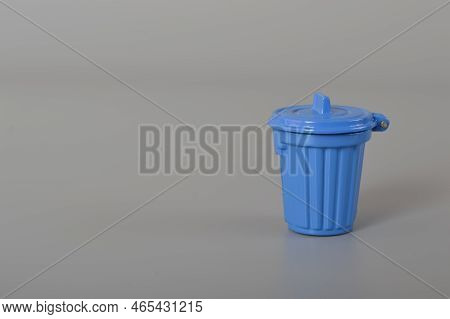 Blue Trash Can Isolated On A Blue Background. Copy Space For The Text