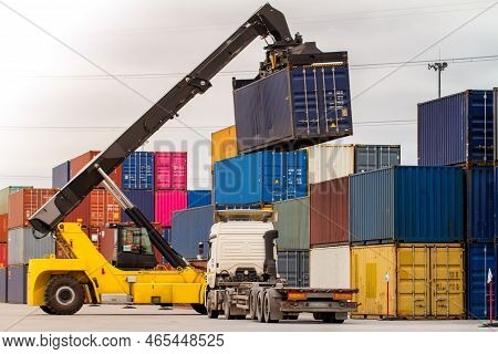 Truck While Loading In Logistic Shipping Yard With Cargo Container. Forklift Truck Handling Truck. L