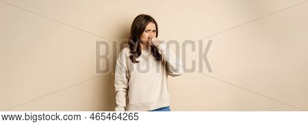 Woman Expressing Disgust Of Bad Disgusting Smell, Close Nose And Grimaing From Dislike, Standing Ove