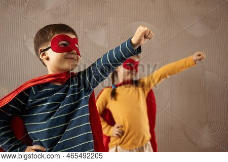Portrait Of A Team Of Two Young Superheroes, Brother And Sister, Over Beige Background. Superhero Ch