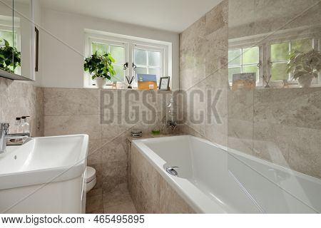 Saffron Walden, Essex, England - Sept 4 2018: Luxury Stylish Tiled Bathroom With Shower Screen, Bath