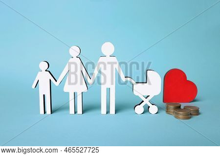 Figures Of Family Stainding Near Heart And Coins On Light Blue Background. Insurance Concept