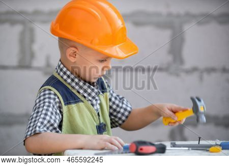 Kid In Hard Hat Holding Hammer. Little Child Helping With Toy Tools On Construciton Site. Kids With 